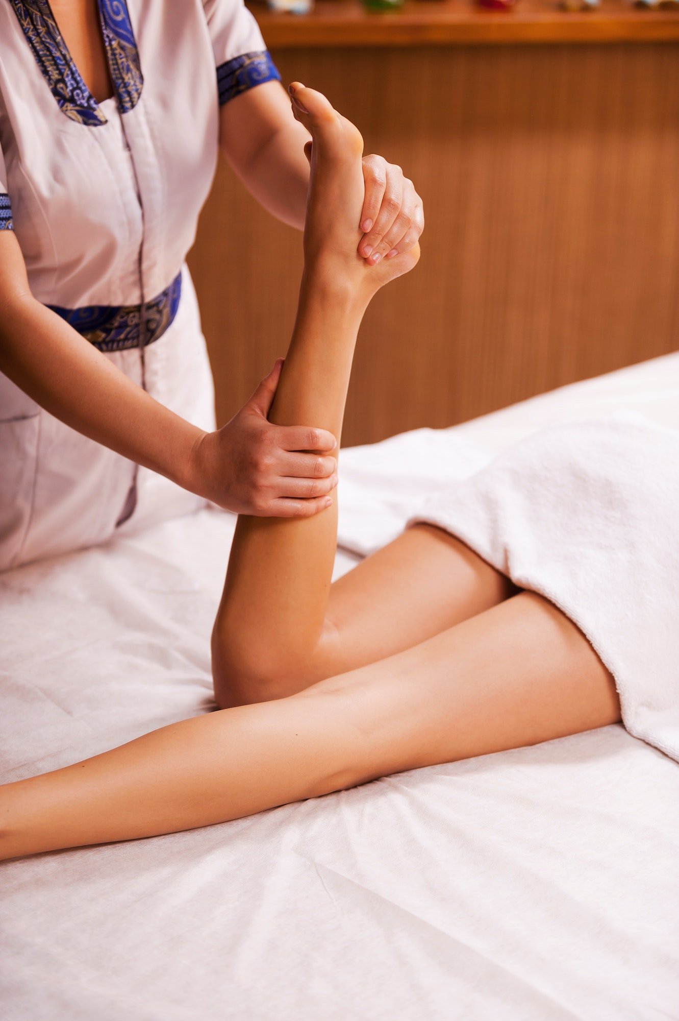 Massaging legs. Top view of massage therapist massaging beautiful female leg